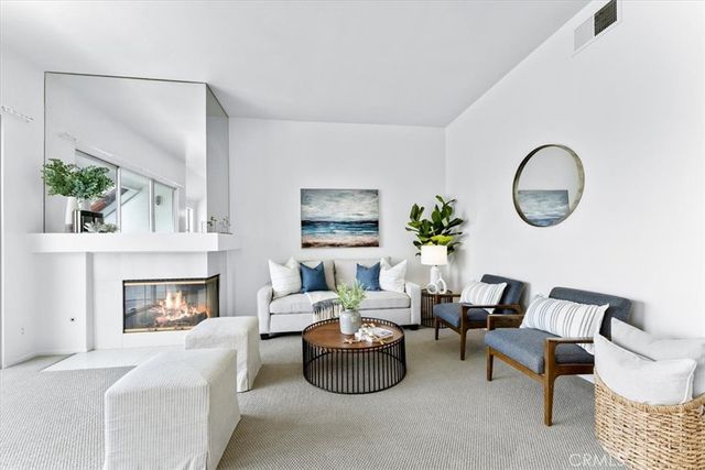 a living room with furniture a fireplace and a potted plant