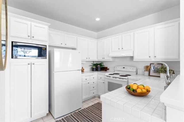 a kitchen with stainless steel appliances a stove a sink and a refrigerator