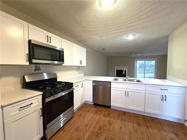 a kitchen with granite countertop sink stainless steel appliances and cabinets