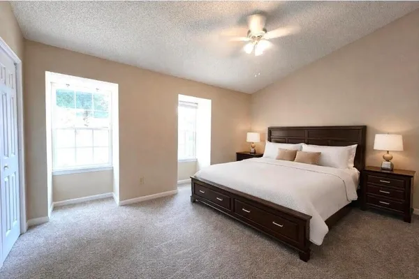 a spacious bedroom with a bed and a ceiling fan