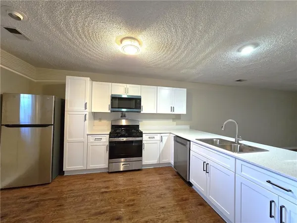 a kitchen with a sink refrigerator and microwave