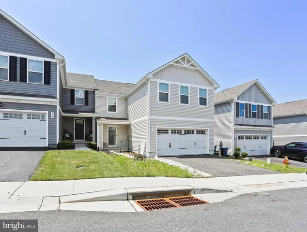 a front view of a house with a garden and parking