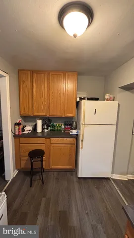 a kitchen with a refrigerator a stove a sink and a dishwasher with wooden floor