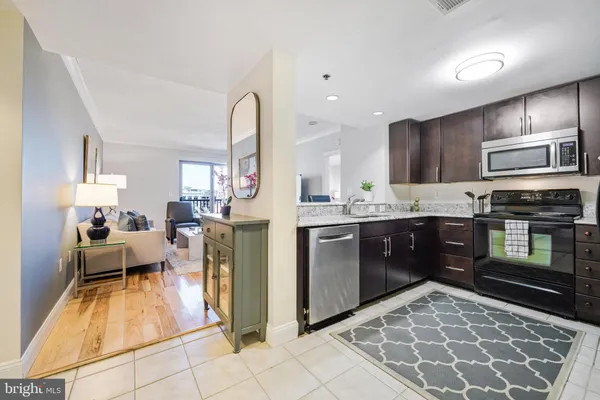 a large kitchen with kitchen island granite countertop a large counter top stainless steel appliances and cabinets