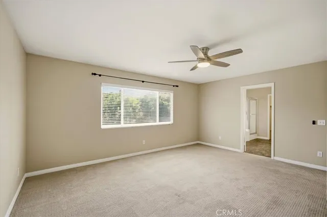an empty room with a window and a fan