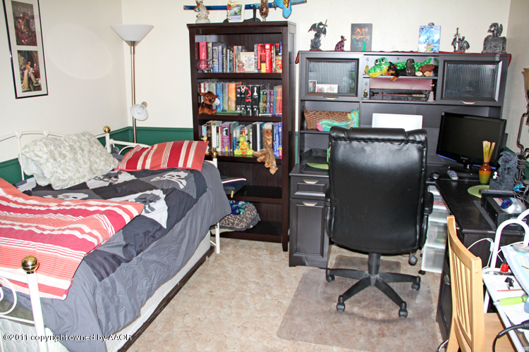 5210 South Travis Street Amarillo, TX 79110 - Photo 14 of 29 a living room with furniture cabinets and a book shelf