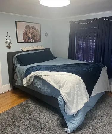 a bedroom with a bed and painting on the wall