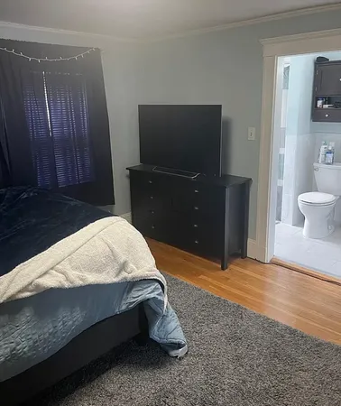 a bed sitting in a bedroom and bathroom