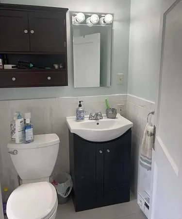 a bathroom with a toilet sink and mirror