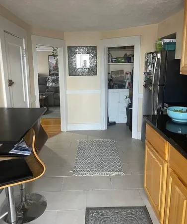 a living room with furniture and a refrigerator