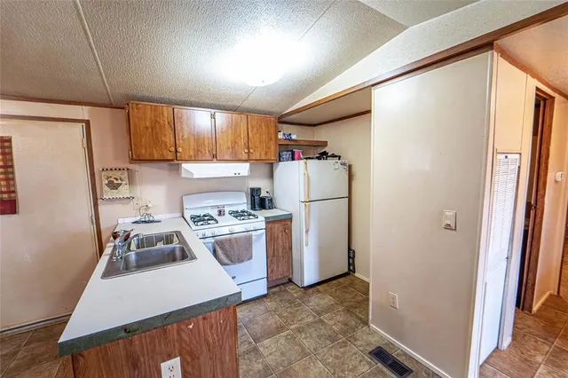 a kitchen with a refrigerator a stove a sink dishwasher and a refrigerator