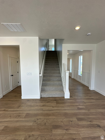 1225 West 500 South Logan, UT 84321 - Photo 22 of 39 Open concept interior featuring wood-finish flooring, a carpeted staircase with white railings, recessed lighting, and white walls with wainscoting in the hallway
