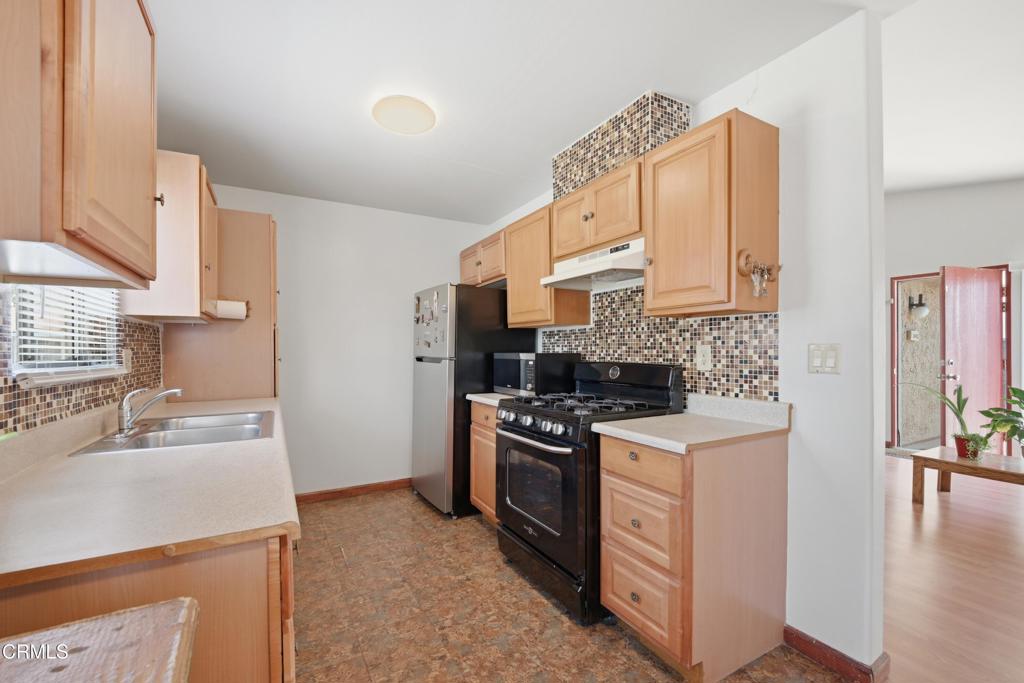 5154 Jefferson Square Oxnard, CA 93033 - Photo 11 of 23 a kitchen with stainless steel appliances granite countertop a sink stove and refrigerator