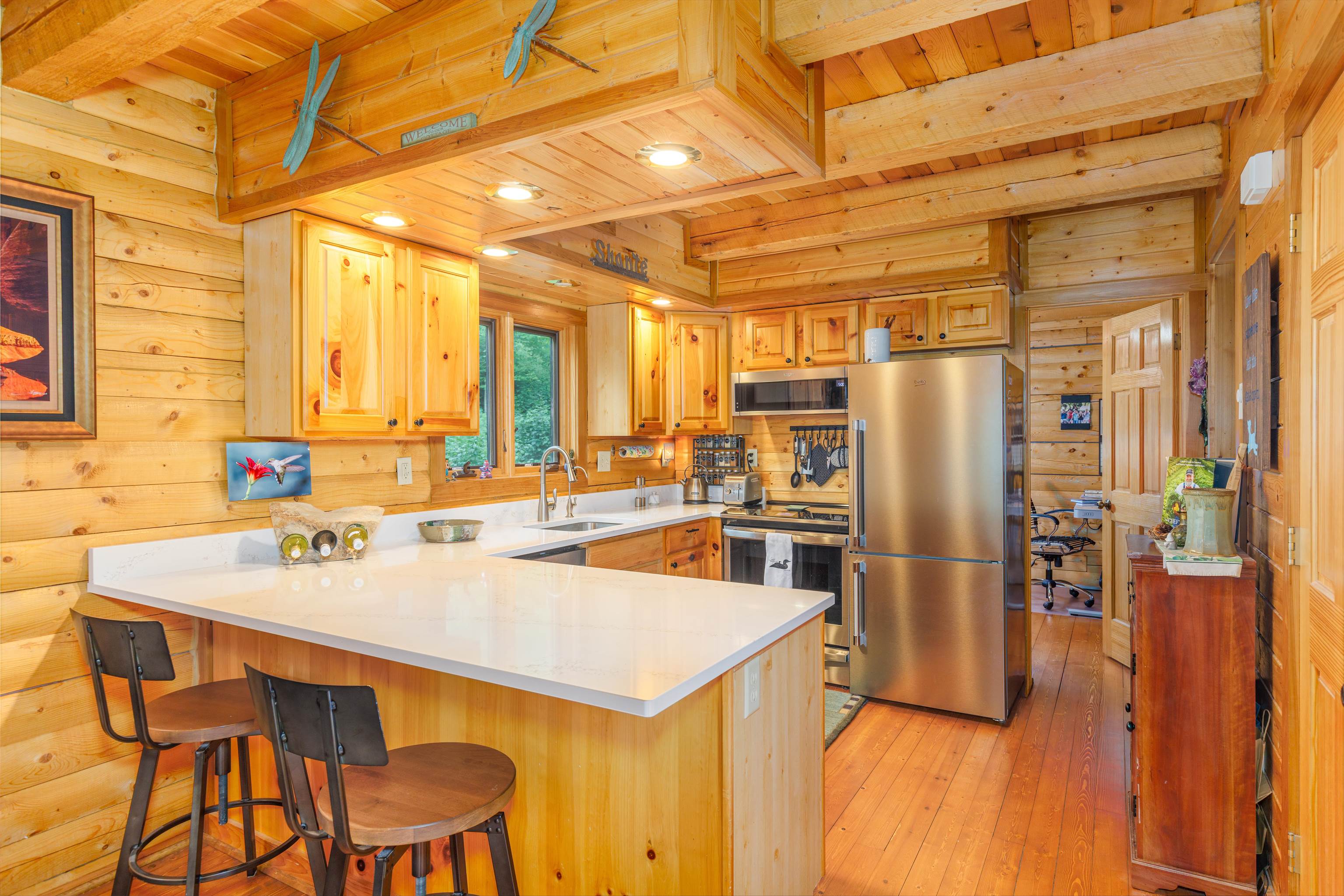 540 Loop Road Ely, MN 55731 - Photo 2 of 20 Kitchen with a peninsula, wood ceiling, stainless steel appliances, wood walls, and a breakfast bar area