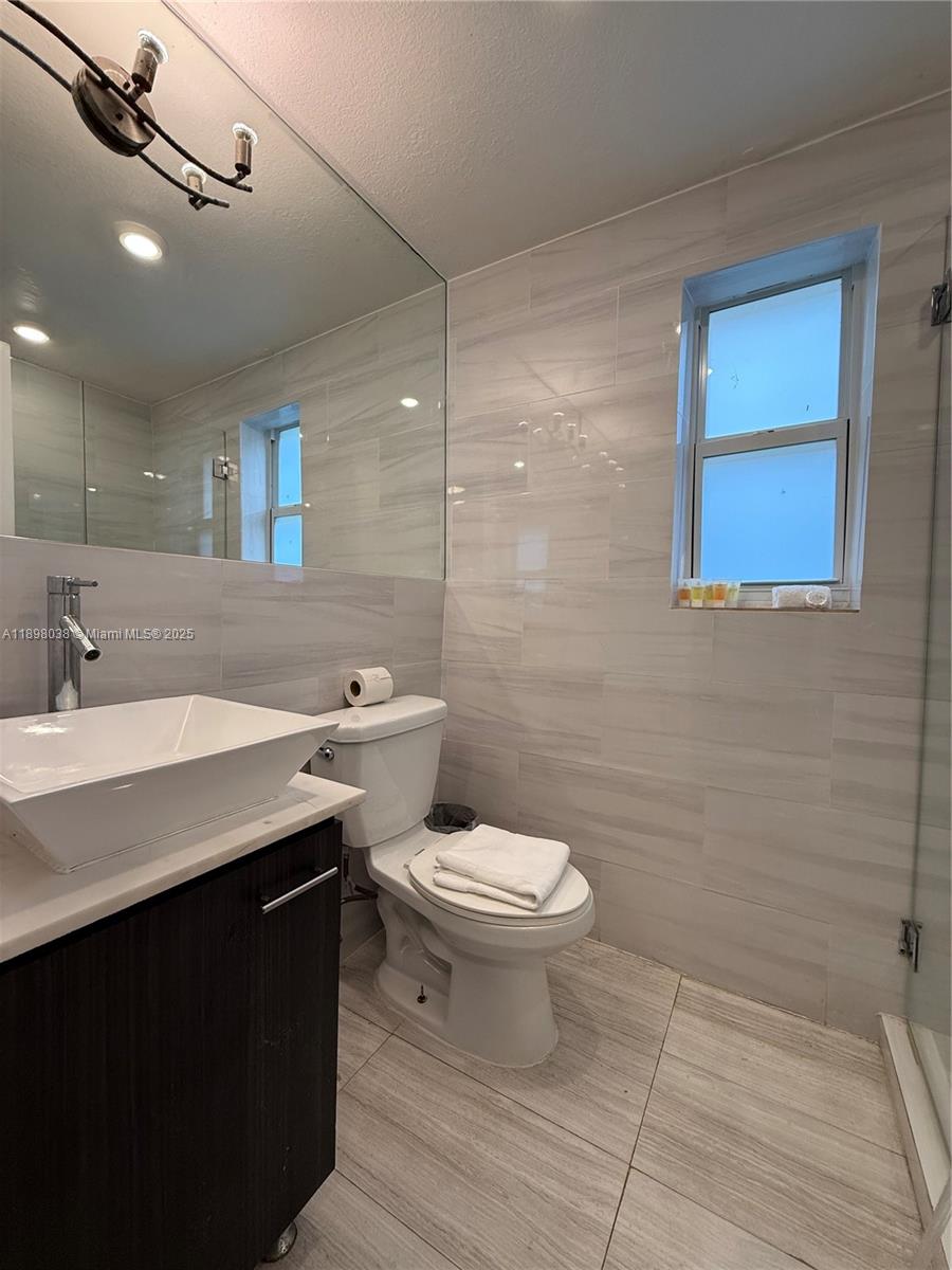 7710 Harding Avenue, Unit 1 Miami Beach, FL 33141 - Photo 14 of 14 a bathroom with a sink a toilet and mirror