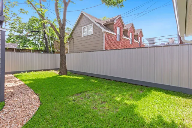 a view of a backyard with chairs and a tree