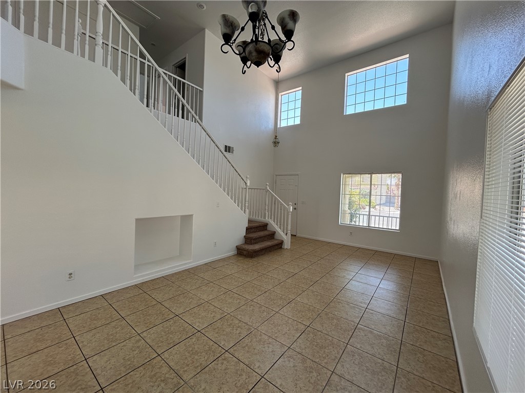 7373 Randel Jean Way Las Vegas, NV 89113 - Photo 3 of 14 Towering ceilings and tile flooring create an airy entryway with an elegant staircase.