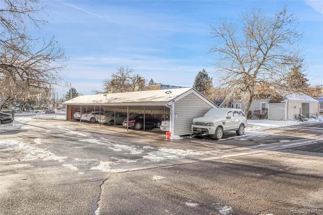 a roof deck with a table and chairs under a large tree