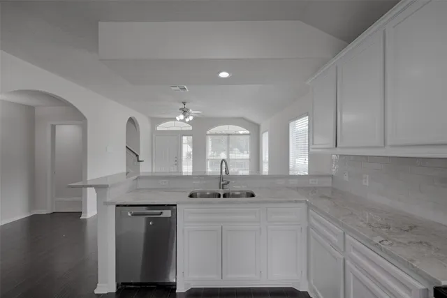 a view of a kitchen with granite countertop a sink stainless steel appliances and cabinets