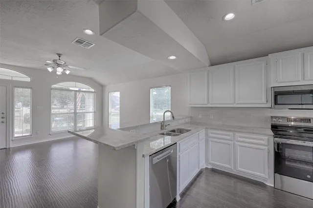 a kitchen that has a lot of cabinets in it and kitchen with wooden floor