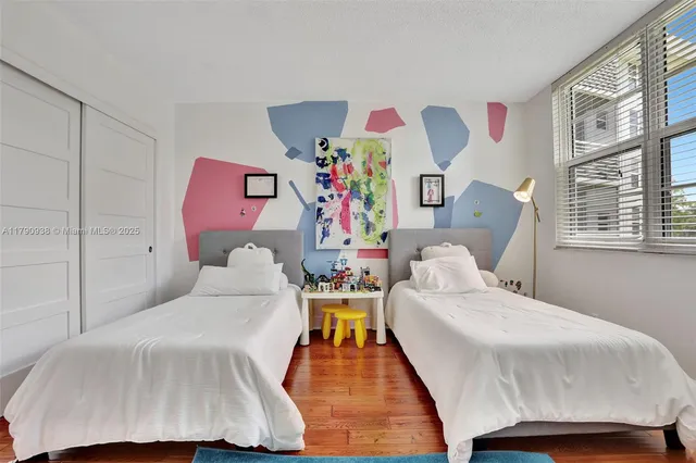 a bedroom with two beds and a large window