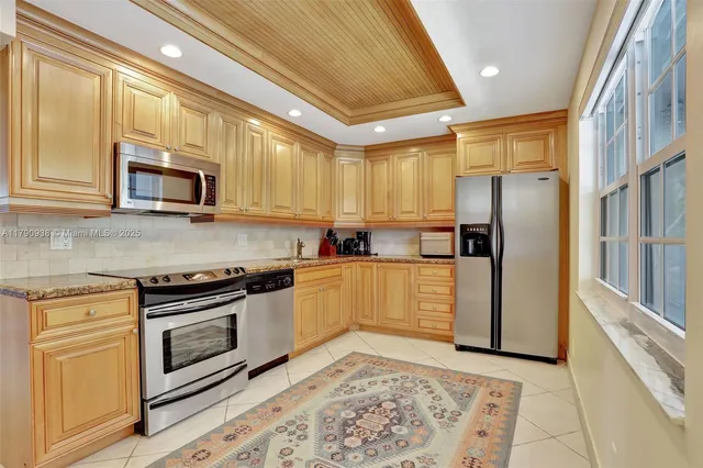 a kitchen with stainless steel appliances granite countertop a stove a refrigerator and a microwave