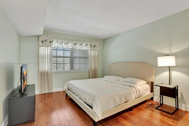 a bedroom with a bed and wooden floor