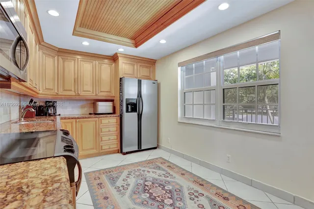 a kitchen with stainless steel appliances granite countertop a refrigerator and a sink