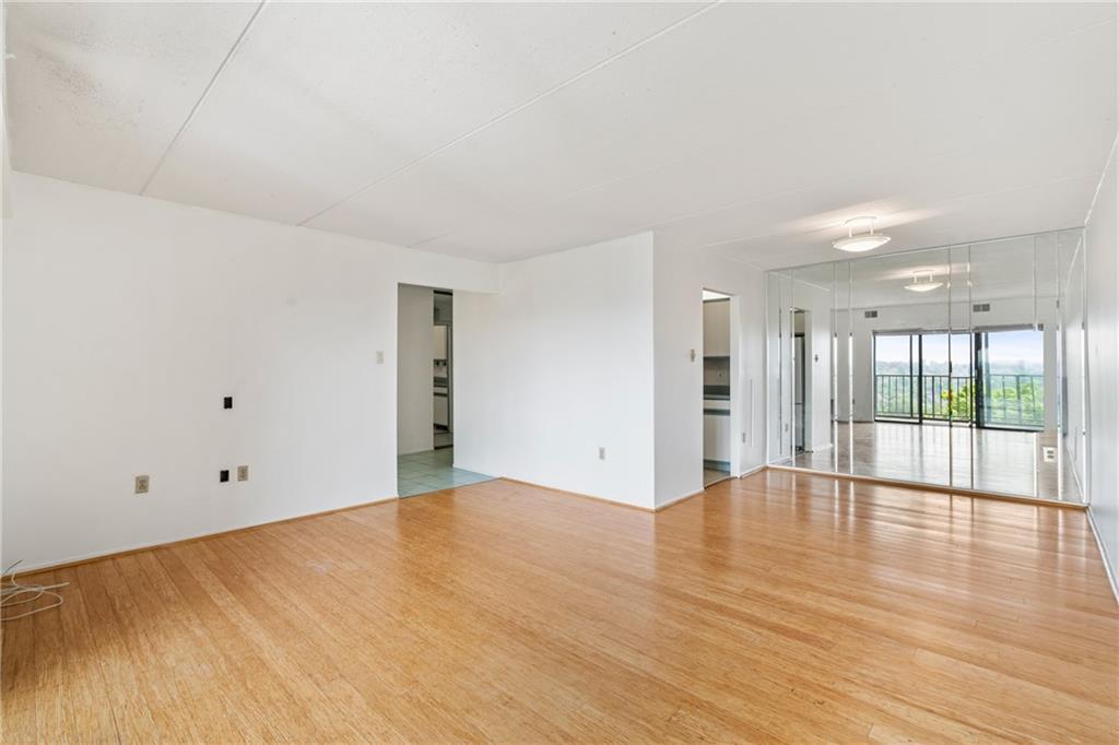 5600 Munhall Road, Unit 606 Pittsburgh, PA 15217 - Photo 5 of 19 a view of an empty room with wooden floor and a window