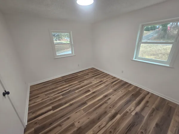 a view of a room with wooden floor and window