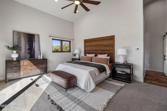 a bedroom with a bed a couch and a chandelier