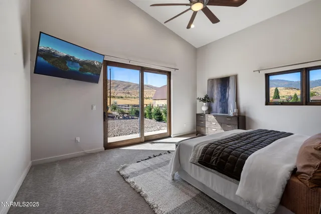 a bedroom with a large bed and a flat tv screen on dresser