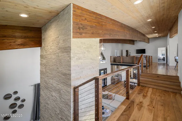 a kitchen with stainless steel appliances kitchen island granite countertop a refrigerator a stove and a wooden floors