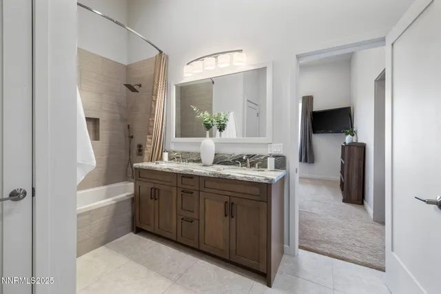a bathroom with a granite countertop sink mirror and a bathtub