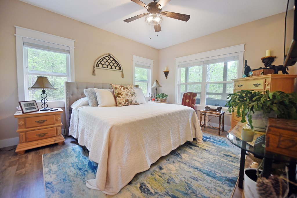 83 Highland Road Blairsville, GA 30512 - Photo 20 of 32 a bedroom with a bed and a chandelier