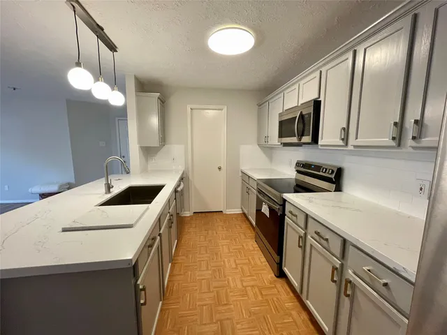 a kitchen with a sink a stove and microwave
