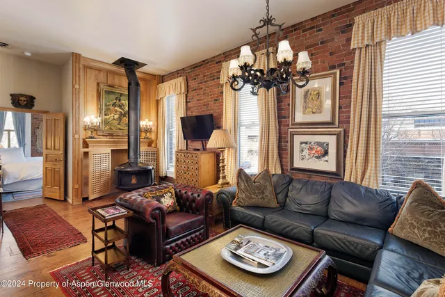 a living room with furniture a fireplace and a chandelier