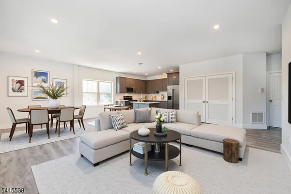 a living room with furniture and a dining table with kitchen view