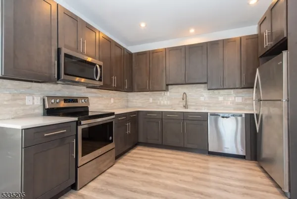 a kitchen with stainless steel appliances granite countertop a stove microwave and sink