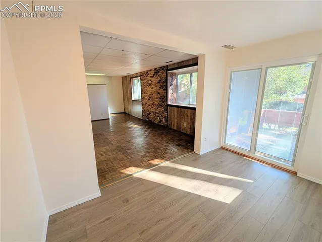 a view of a room with wooden floor and windows