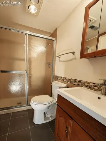 a bathroom with a granite countertop sink mirror vanity and toilet