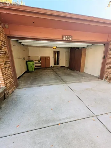 a view of a brick house with a large window and potted plants
