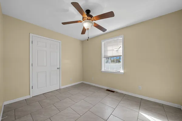 an empty room with a ceiling fan and carpet