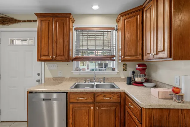 a kitchen with stainless steel appliances kitchen island granite countertop a refrigerator and a sink