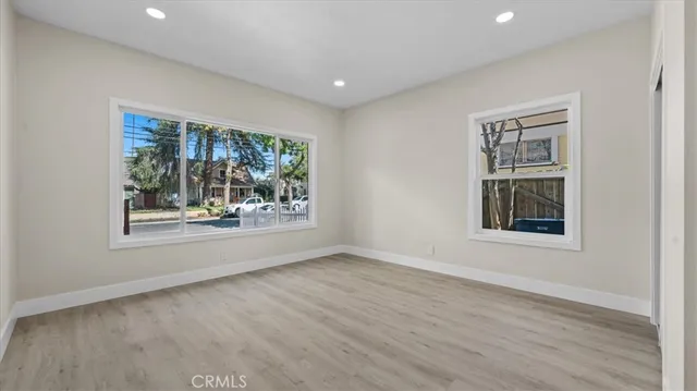 an empty room with wooden floor and a window