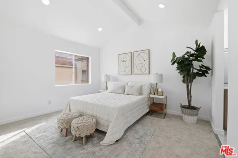 a bedroom with a bed and a potted plant