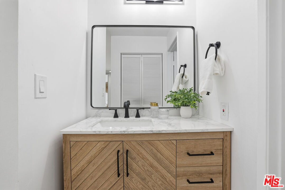 19834 Sandpiper Place, Unit 64 Newhall, CA 91321 - Photo 29 of 40 a bathroom with a granite countertop sink and a mirror