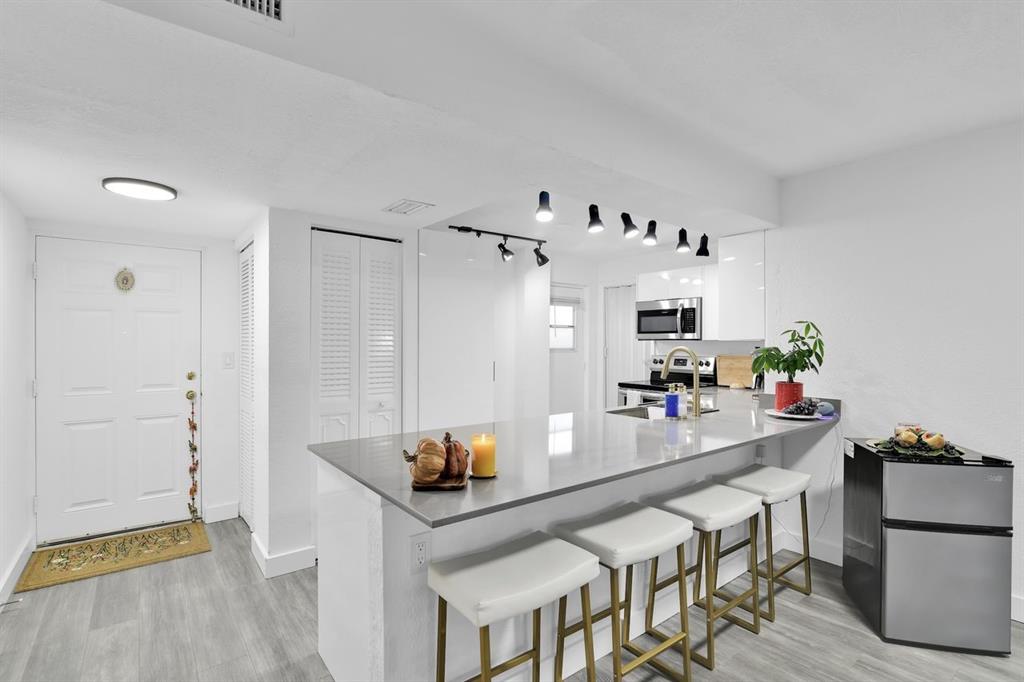 a kitchen with stainless steel appliances a table and chairs in it