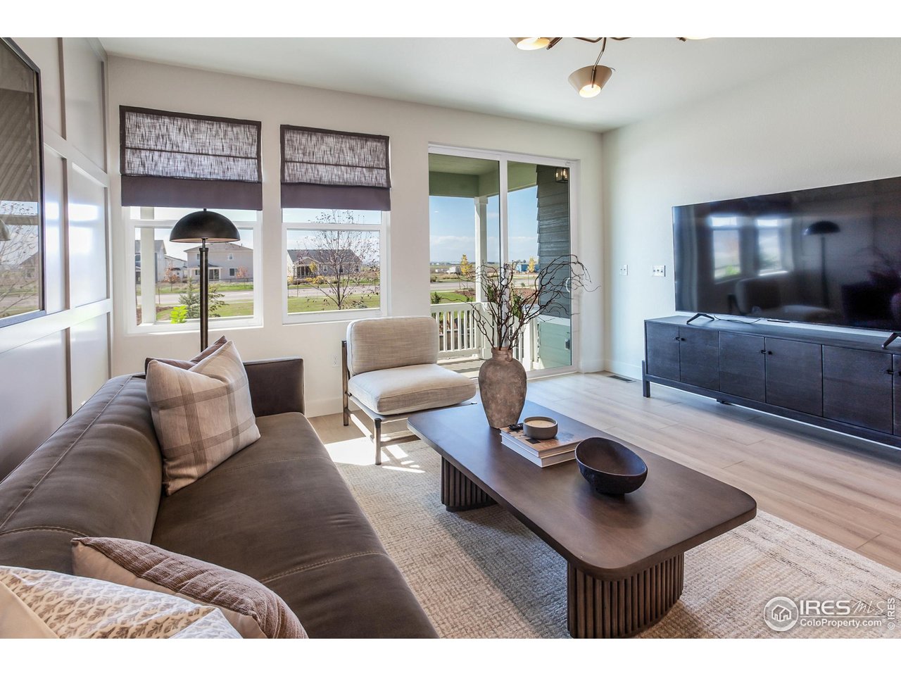 792 Chatter Road Windsor, CO 80550 - Photo 12 of 42 a living room with furniture and a flat screen tv