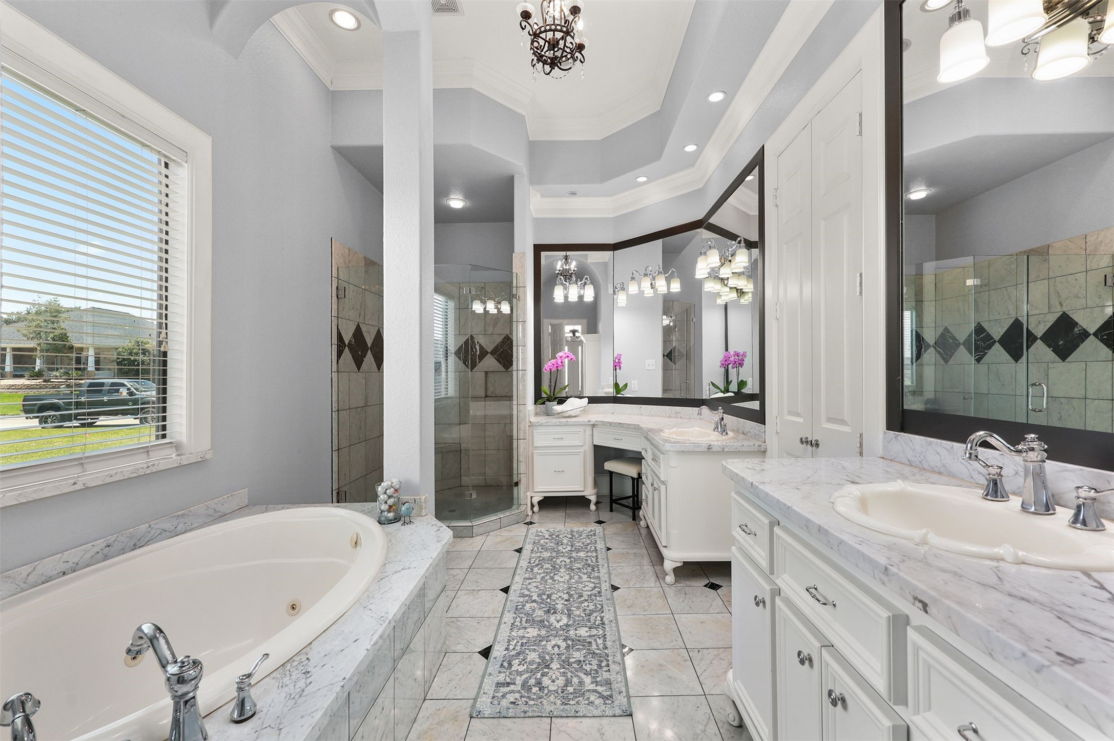 10896 Decatur Street Willis, TX 77318 - Photo 33 of 50 Indulge in this luxurious bathroom retreat featuring dual marble sinks, a jacuzzi tub, a spacious walk-in shower, elegant lighting, a stylish rug, and abundant natural light.